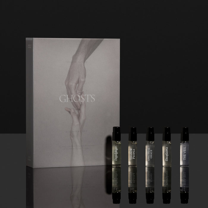 Set of perfume bottles with a 'Ghosts' packaging on a reflective surface.