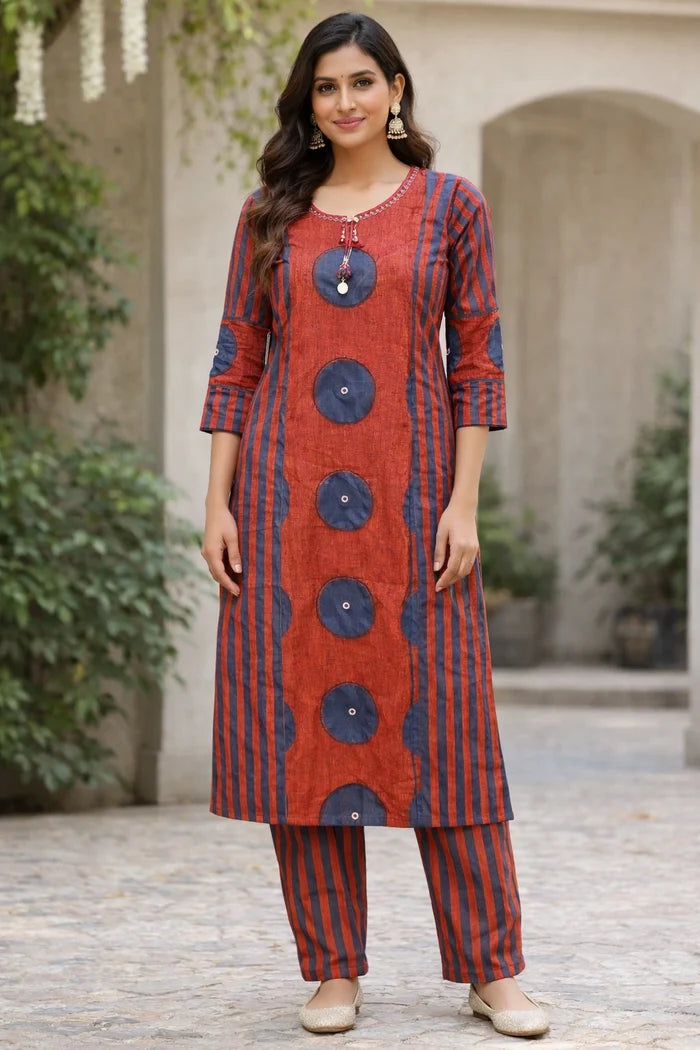 Woman wearing a red and blue patterned kurta with pants outdoors.