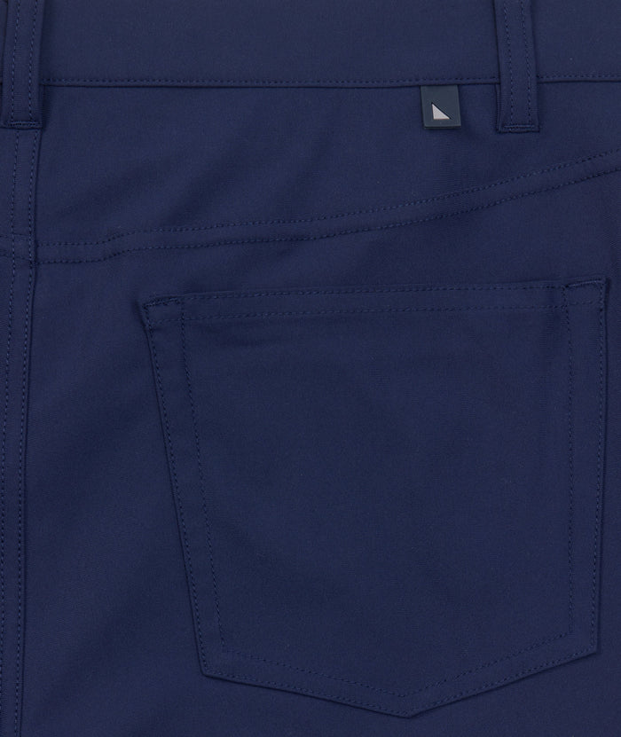 Model is wearing UNTUCKit 5-Pocket Performance Tech Pants in Navy.