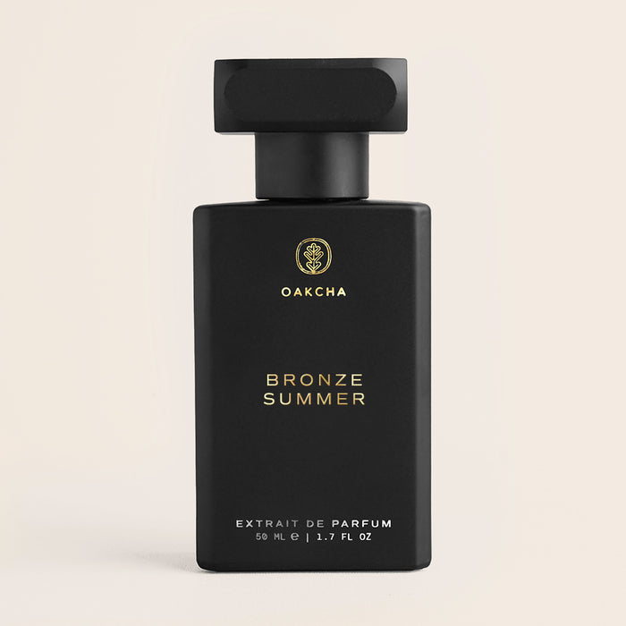 Front view of Bronze Summer 50 ml perfume bottle showing matte black rectangular bottle and gold Oakcha logo on beige background