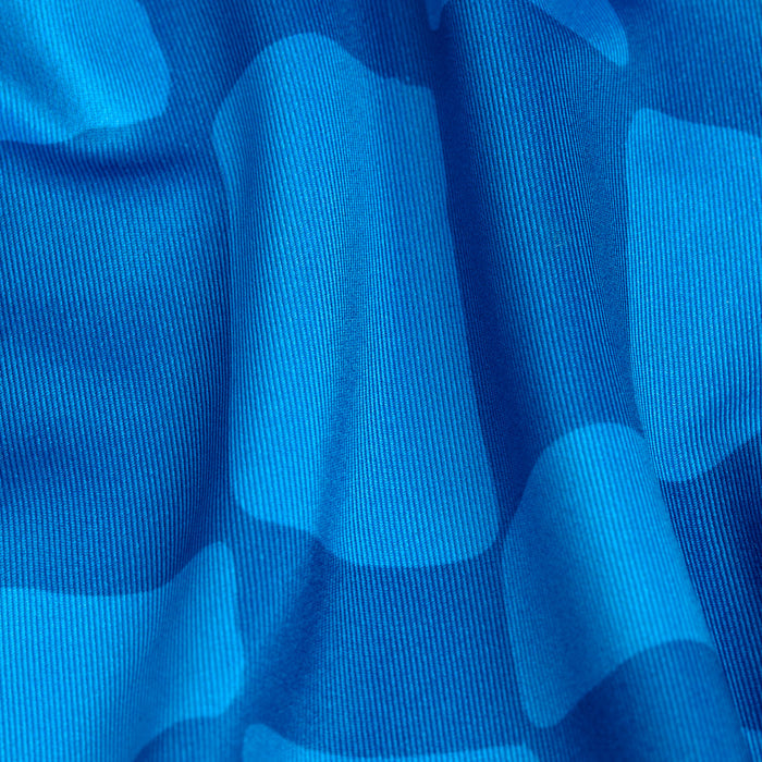 Close-up of the Checked Out - Polo, showcasing its blue checkered fabric in varying shades, vertical ribbed texture, soft folds, and shadows. Moisture-wicking properties help keep you dry and comfortable.