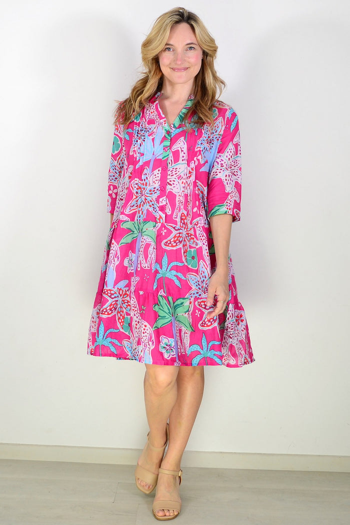 Colorful pink Beth tunic dress by One Summer, featuring vibrant patterns and flowing fabric, displayed on a hanger.