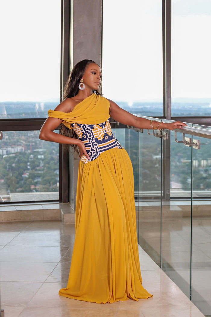 mustard one shoulder formal dress, African print corset evening gown, FabroSanz luxury dresses, pleated mustard yellow gown South Africa, printed corset bodice dress, modern African formal wear, statement evening dresses for women, South African designer gowns, elegant formalwear for black women, high fashion African dresses, draped shoulder evening dress, gala dresses with African flair, structured corset dress with pleats, luxury womenswear South Africa, event dresses inspired by African fashi