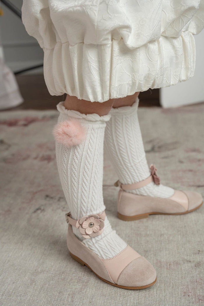 Faina pink leather mary janes with delicate flower strap detail paired with white ribbed knee-high socks, perfect for special occasions
