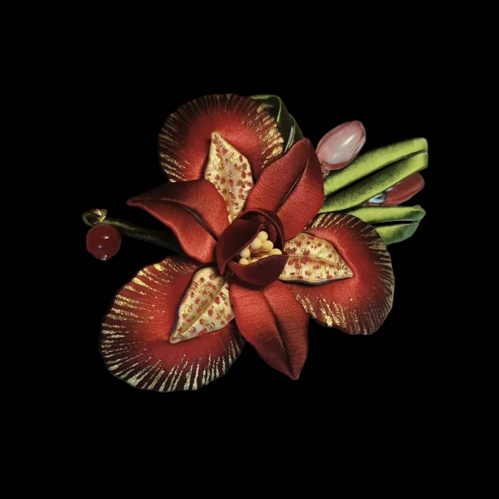 Handcrafted Chanhua iris brooch featuring deep red thread-wrapped petals with golden accents and green leaves.