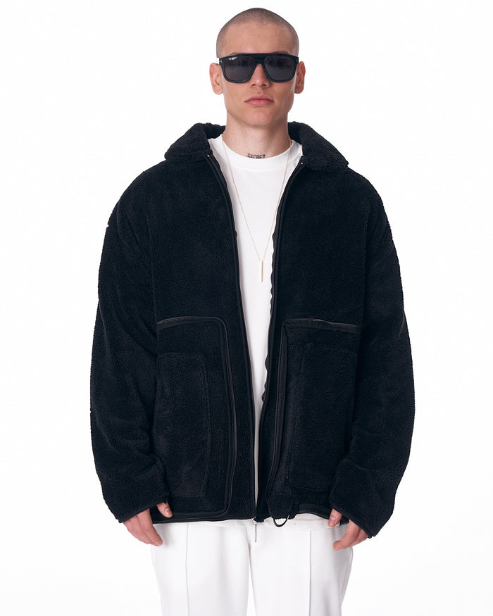 Martin Valen men's black plush cardigan, front mid-body view showing high collar and visible zip closure