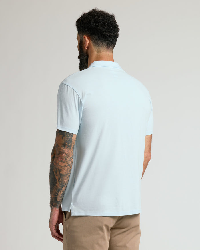Man wearing Icicle Classic Polo with tattooed arm visible.