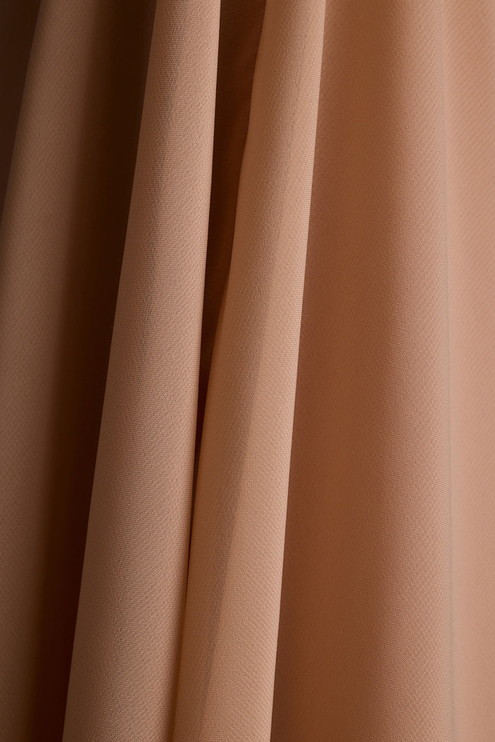 Close-up of draped nude chiffon fabric.