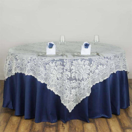Elegant lace tablecloth on a round table with blue satin skirt and decorative napkins.