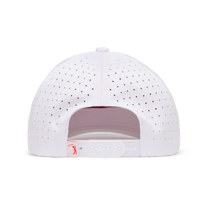Back view of a white baseball cap with small ventilation holes, adjustable plastic snap closure, and a small pink tag on the left side featuring a minimalist logo. The cap has a curved crown and a structured design.