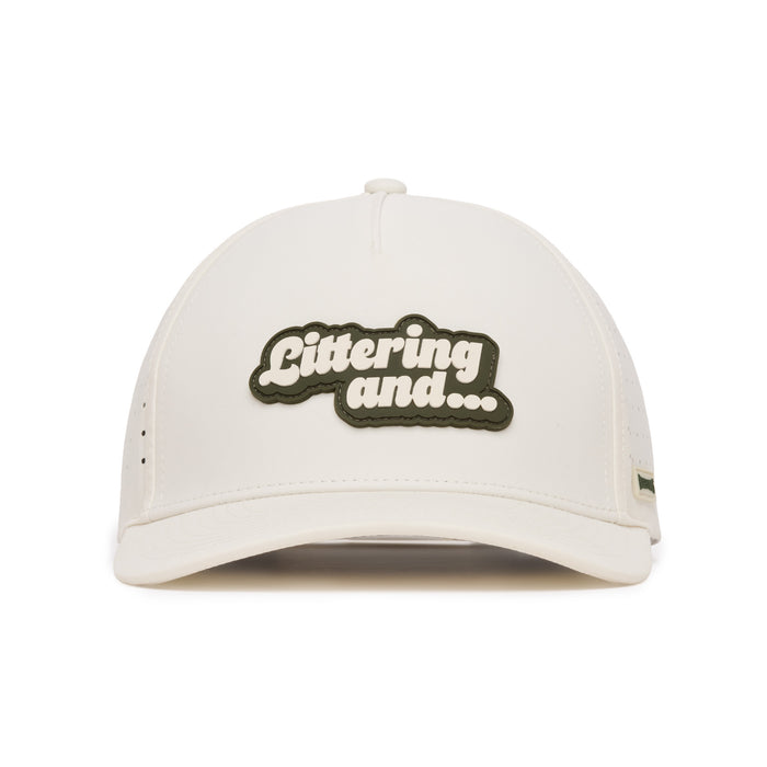 A white baseball cap viewed from the front, featuring a black and white patch in the center with the text Littering and... in bold, rounded letters. The cap has minimal visible detailing and clean lines.