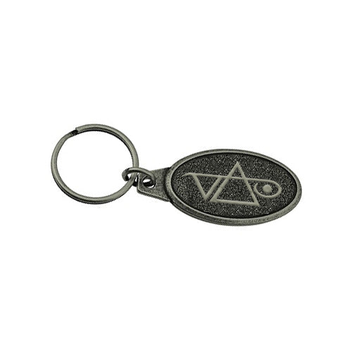 A Steve Vai metal keychain featuring a sturdy metal key ring and an oval pendant engraved with a geometric logo of intersecting lines and a circle.