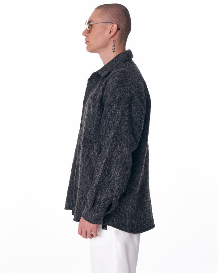 Martin Valen dark grey wool cardigan shown in left profile, side view highlighting collar and relaxed fit