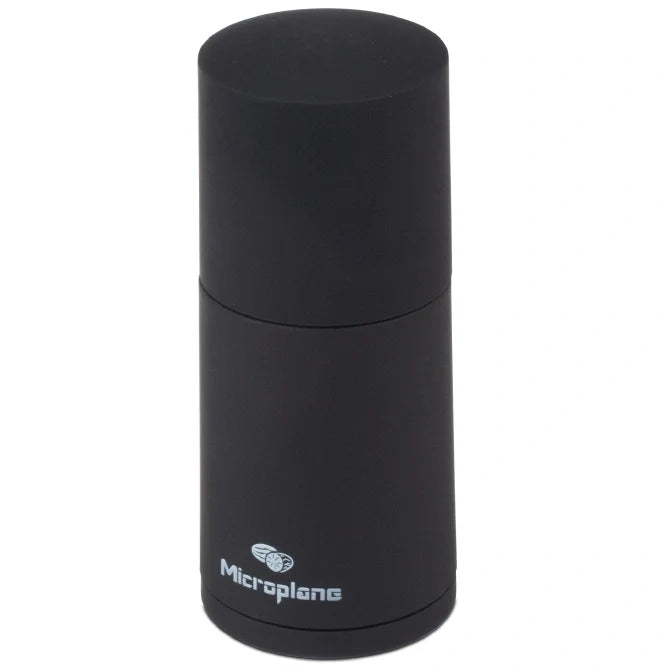 Black cylindrical microplane spice grator on a white background