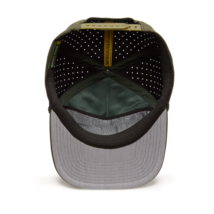 The image shows the inside of a green baseball cap with a gray underside of the brim, perforated black lining, and a yellow band labeled SERIOUSLY FUN. The adjustable strap and stitching details are visible. The cap rests on a white background.