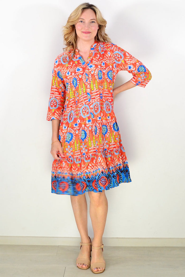 Orange and blue Beth tunic dress by One Summer, featuring a flowing design and casual style, displayed hanging on a wooden hanger.