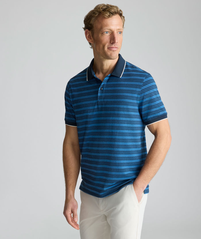 Model is wearing UNTUCKit Performance Hybrid Polo in dark blue.