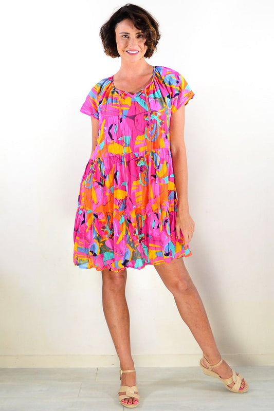 Poppy Cap Sleeve Tassel Dress by One Summer, a stylish tunic with tassel details and cap sleeves, displayed on a hanger.