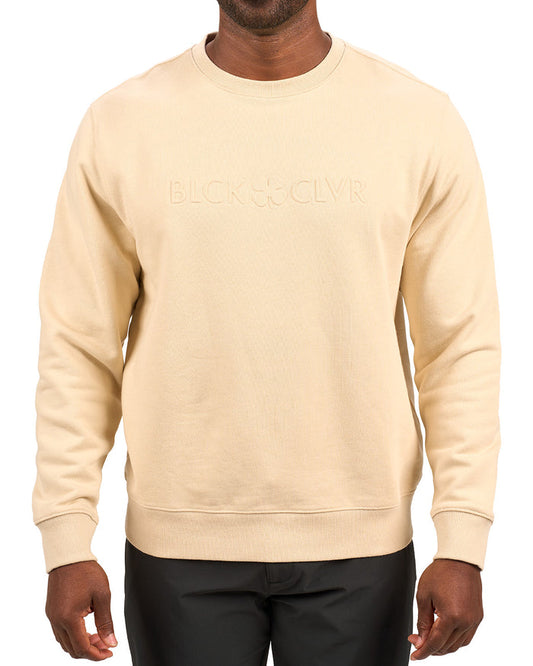 man wearing an oatmeal colored sweater from Black Clover with a 3d text BLCK CLVR on the chest