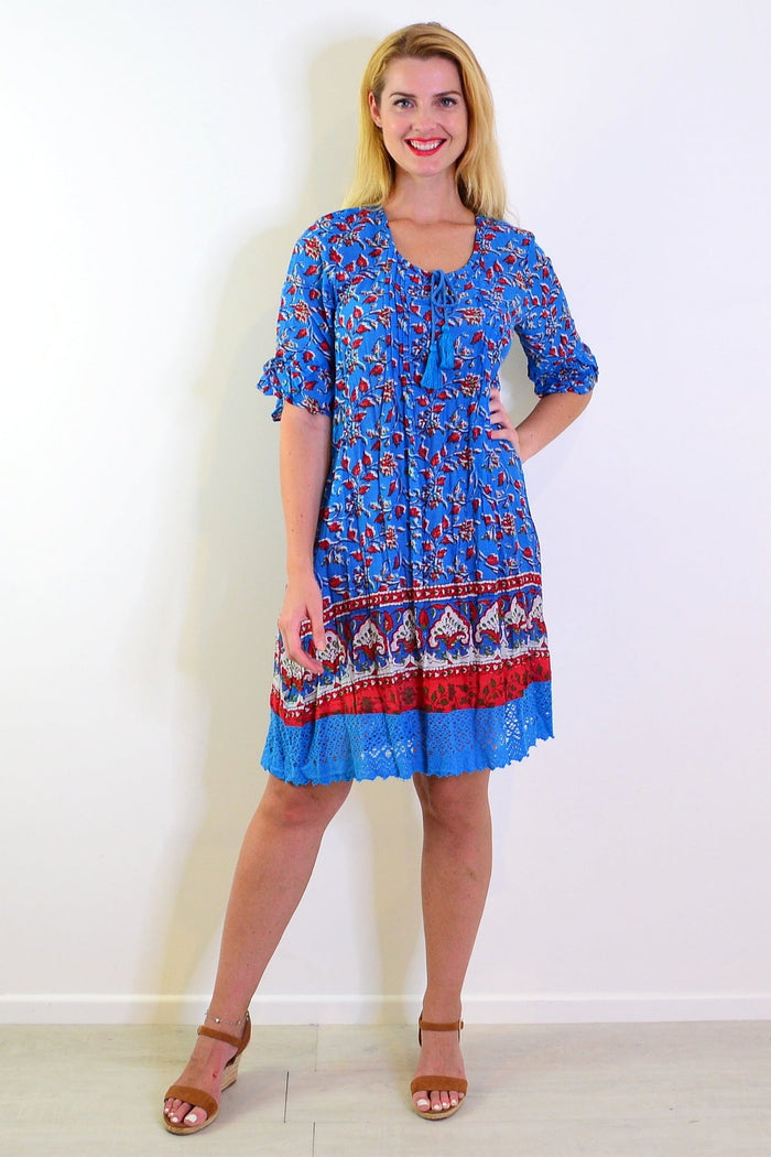 Red and blue Hannah boho tunic dress by One Summer, flowing fabric with bohemian style details, displayed on a hanger.