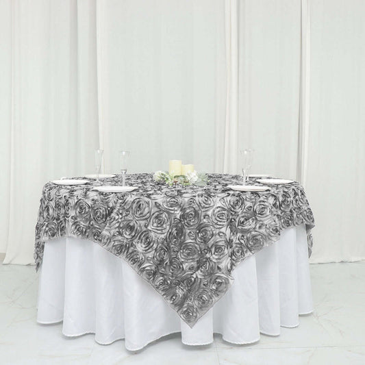 Black and white rose-patterned tablecloth draped over a round table.