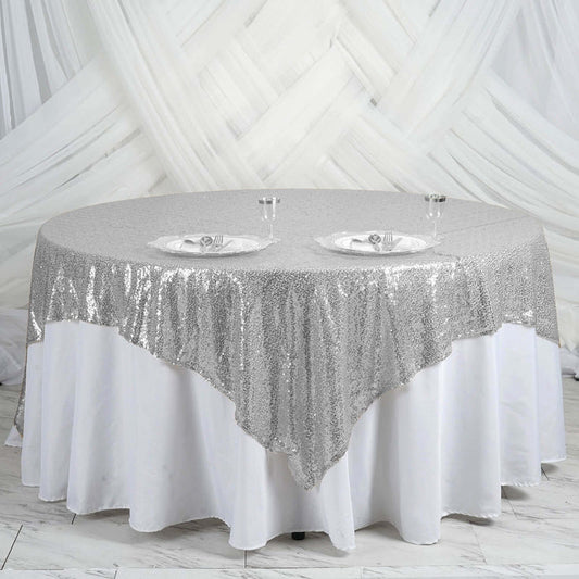 Round silver sequin tablecloth draped elegantly over a white table.