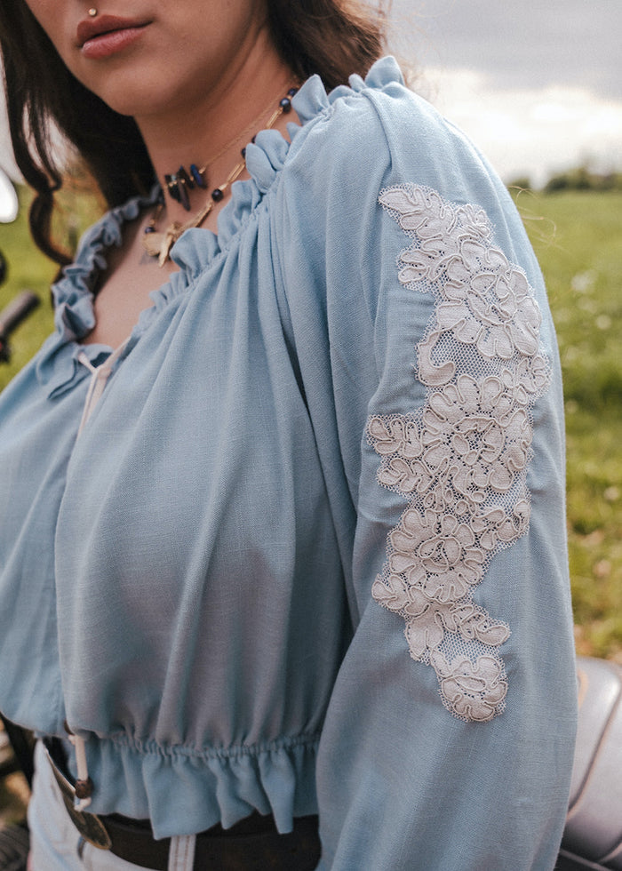Light blue peasant blouse with lace sleeves worn by a person in an outdoor setting clothing by Soul Sister since 1969