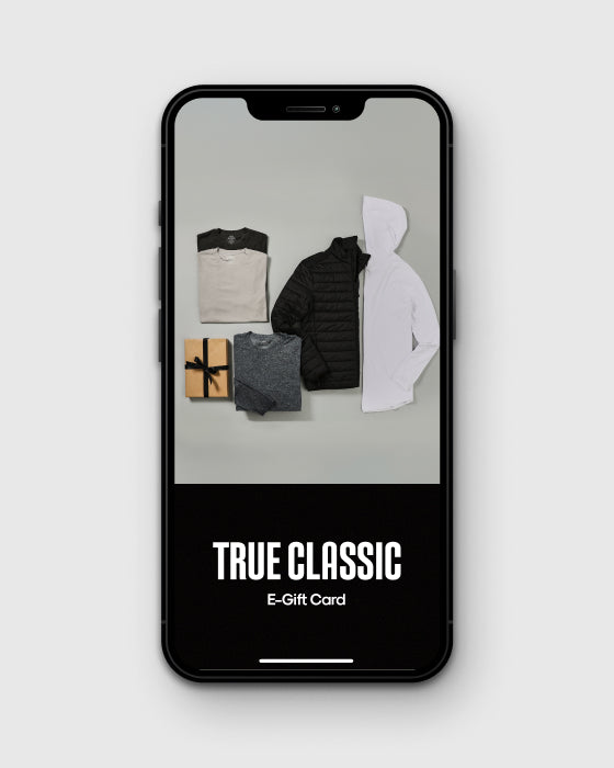 True Classic E-Gift Card on smartphone with apparel and gift box.