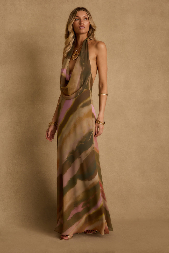 Cowl-neck abstract print maxi dress in olive and pink, styled with gold jewelry as resort evening attire.
