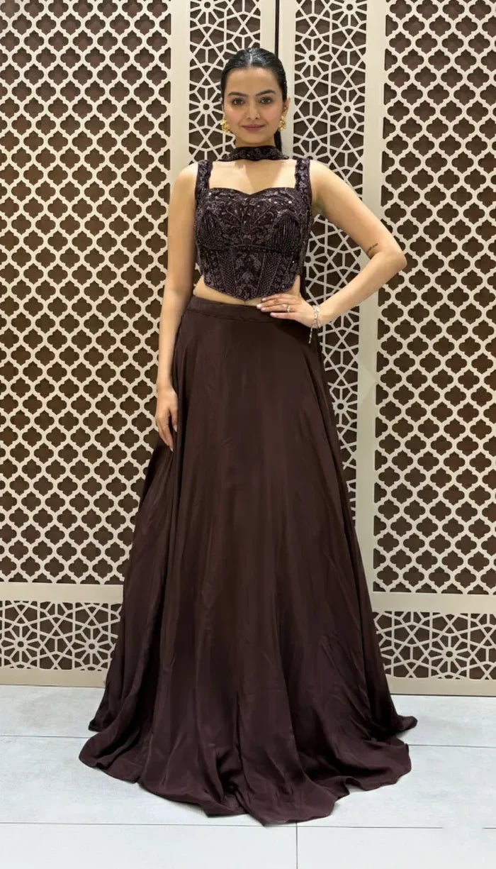 Wine-toned Indo-Western lehenga featuring a heavily embroidered corset-style sleeveless blouse and a floor-length matching skirt.