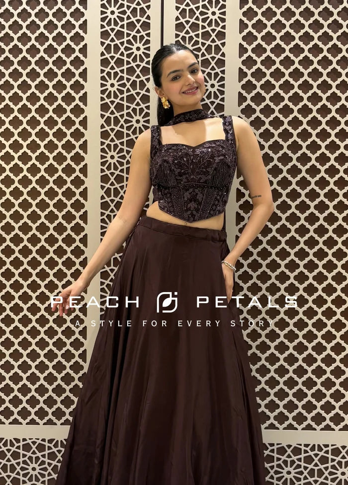 Deep wine-colored Indo-Western lehenga featuring a heavily embellished corset-style blouse and a voluminous flared skirt.