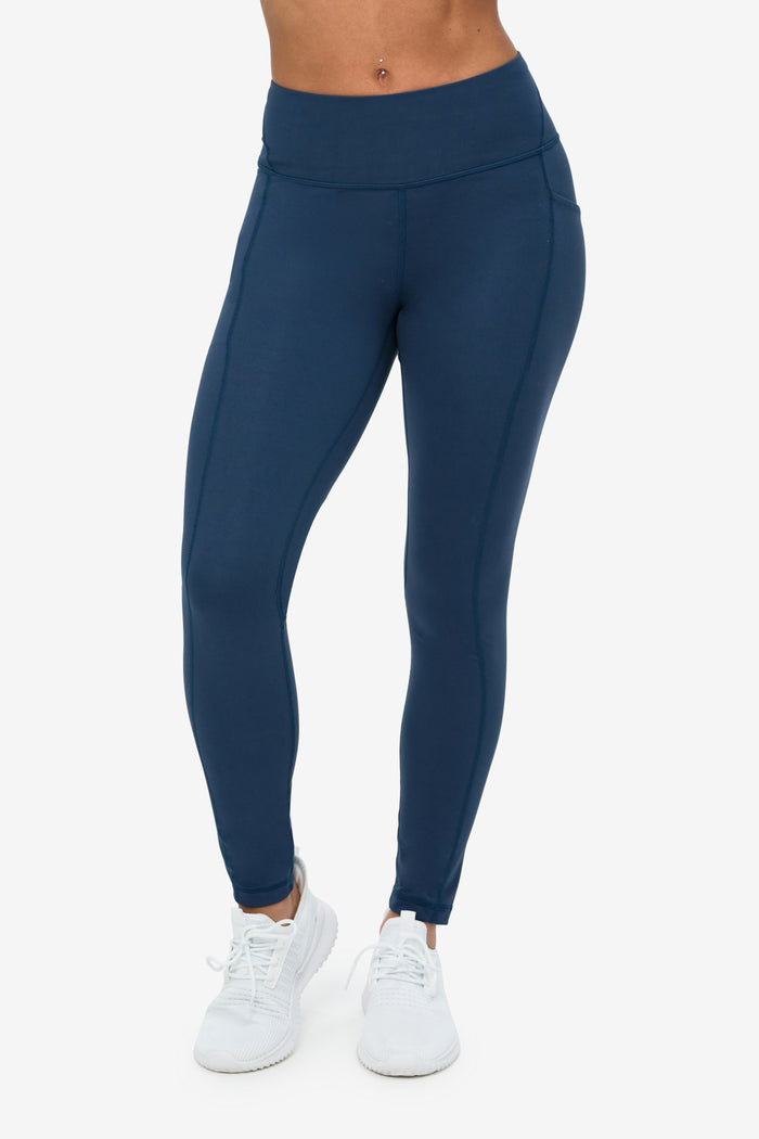 Navy blue leggings worn by a person on a white background