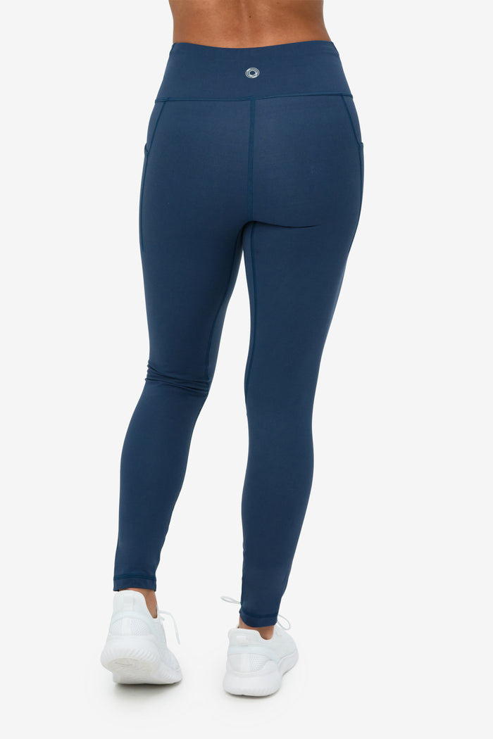 Navy blue leggings worn by a person on a white background