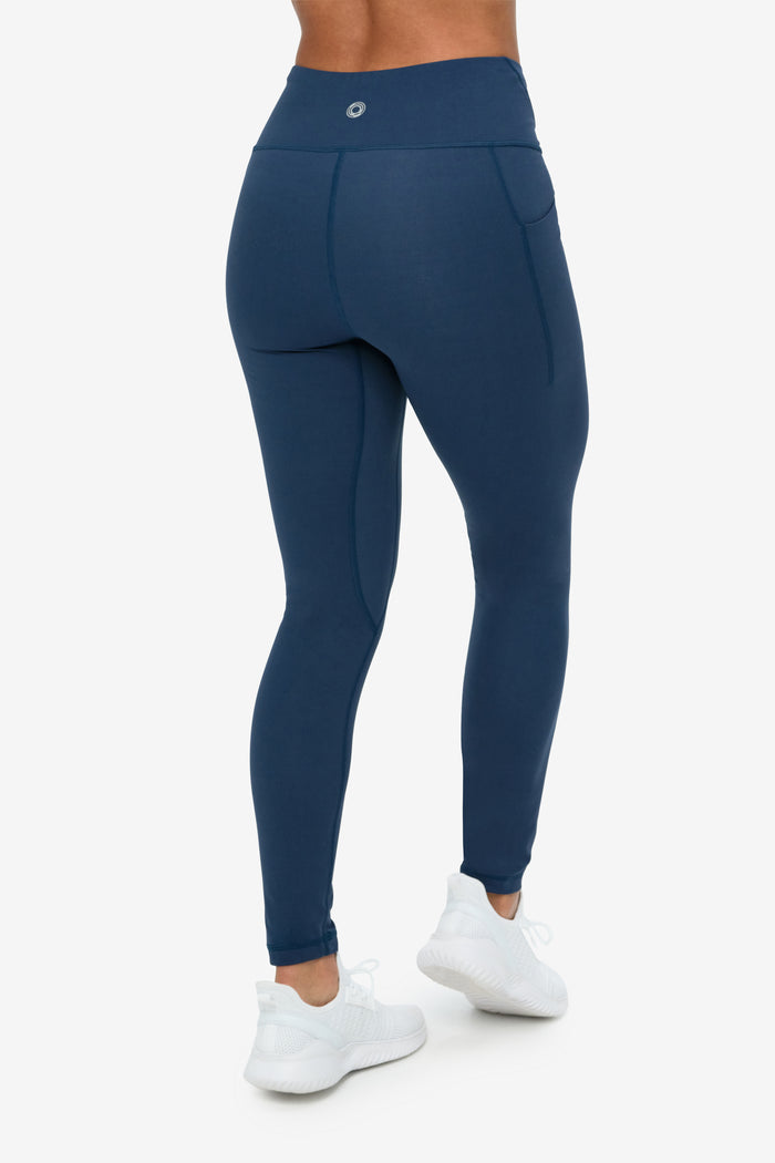 Navy blue leggings worn by a person on a white background